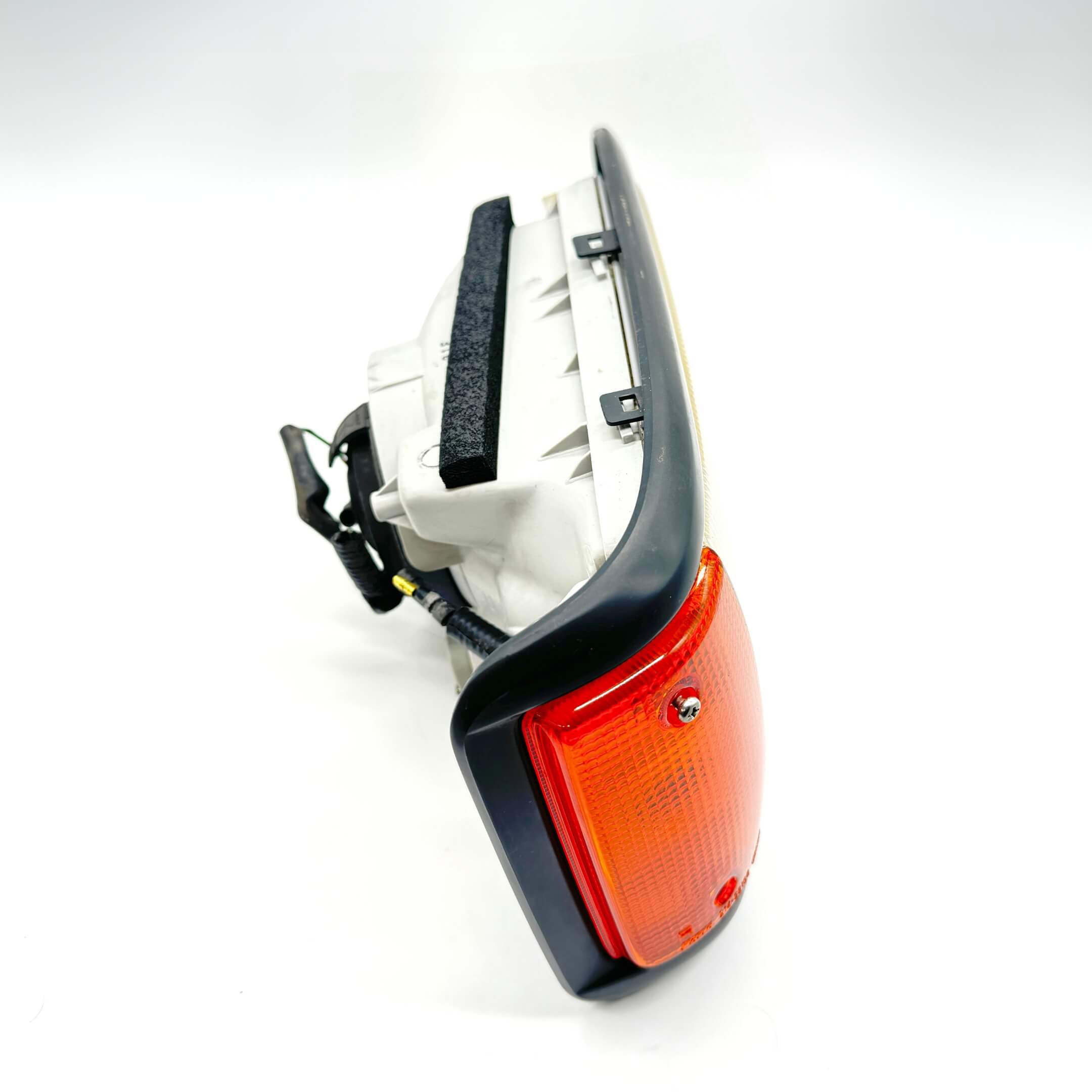 Side view of right headlight assembly for Honda Acty Van HH3, HH4 models 1990-1993 with orange indicator.