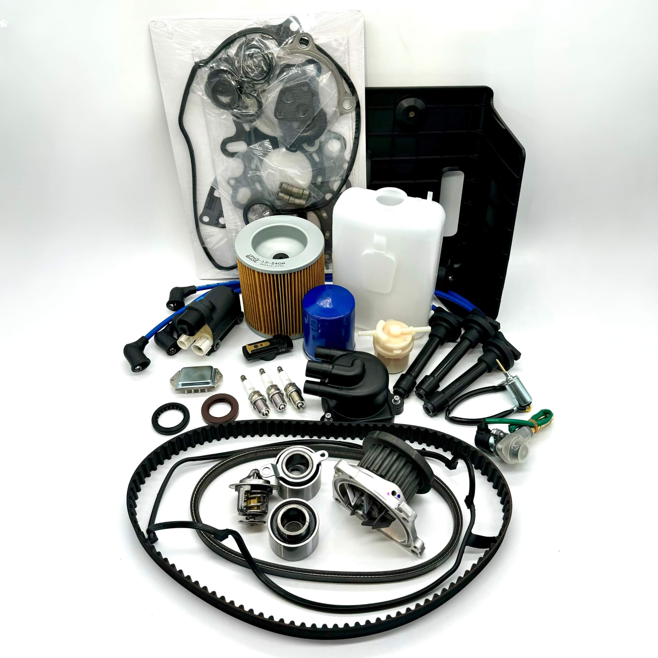 Comprehensive 25-piece Honda Acty HH3/HH4 timing belt and tune-up kit including air, fuel, and oil filters, distributor cap and rotor, spark plugs and wires, ignition control module and coil sensor, ignition assembly, engine gasket set, belts, coolant reserve tank, and battery cover for 1990-1999 models, meticulously packaged for peak performance and free shipping from Oiwa Garage.