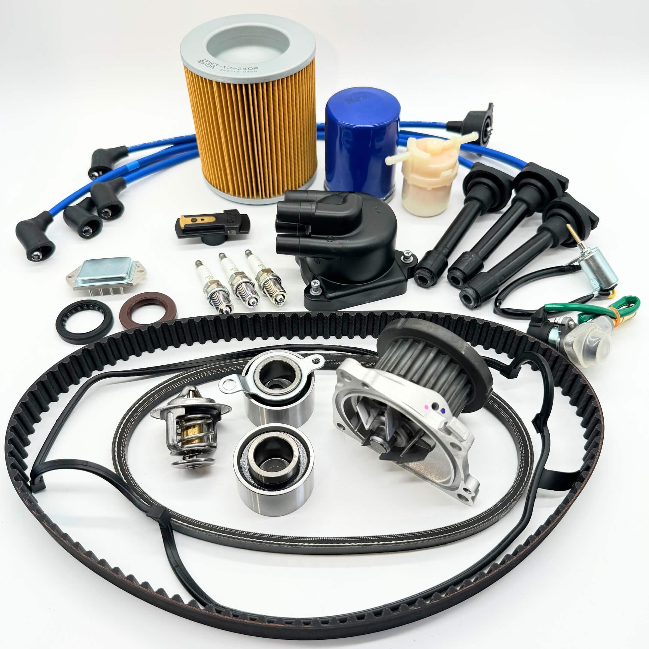 Honda Acty 1990-1999 HH3/HH4 19-piece Mega Timing Belt and Tune-Up Kit on white background, including air and fuel filters, oil filter, distributor cap and rotor, spark plugs with wires, ignition control module, coil sensor, ignition assembly, timing and alternator belts, and head gasket cover kit, available for free shipping at Oiwa Garage.