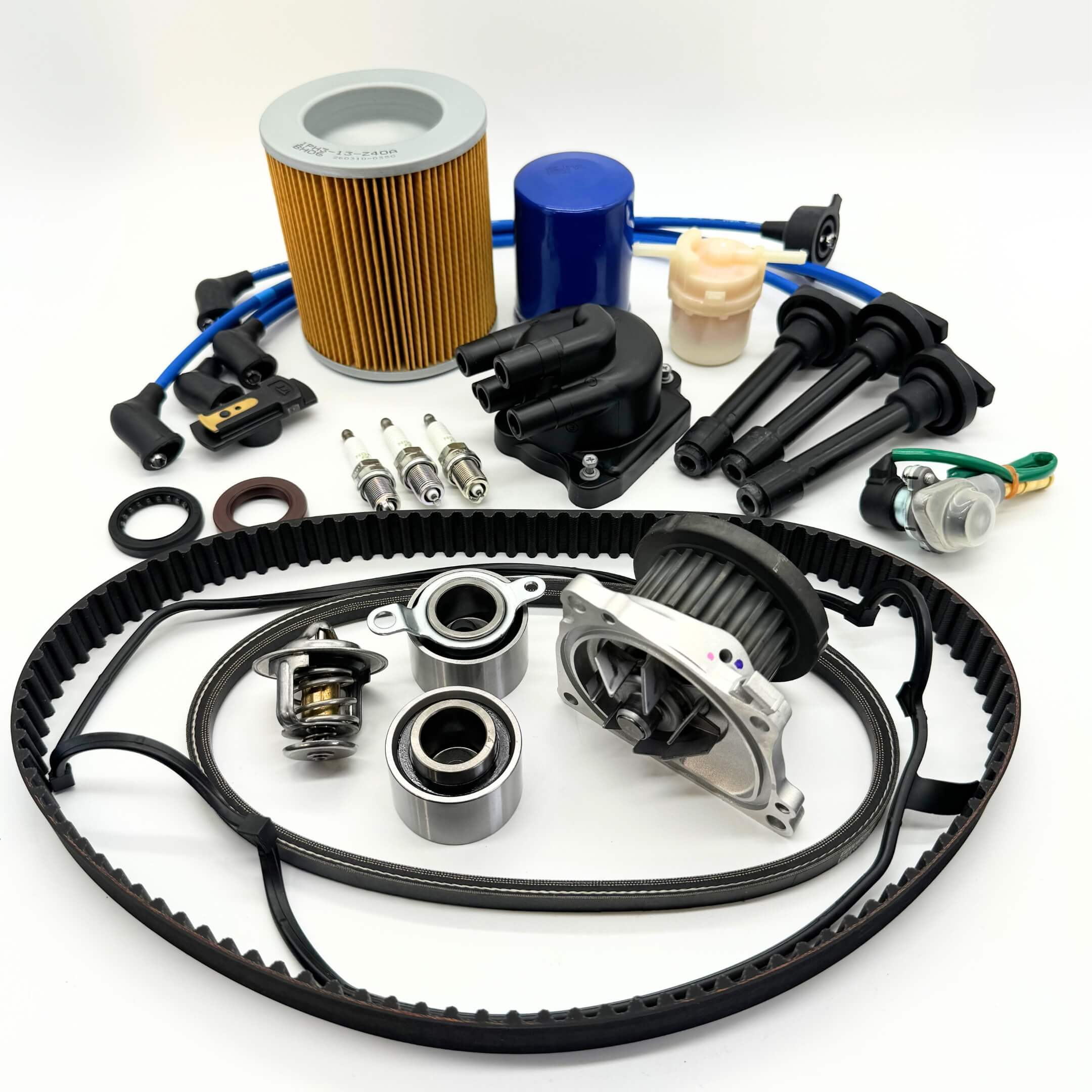 17-piece Mega Timing Belt and Tune-Up Kit for Honda Acty HH3/HH4 1990-1999, including air and fuel filters, oil filter, distributor cap and rotor, high-efficiency spark plugs with wires, timing belt, alternator belt, head cover gasket, and air solenoid, neatly displayed on a white backdrop, available for free shipping from Oiwa Garage.